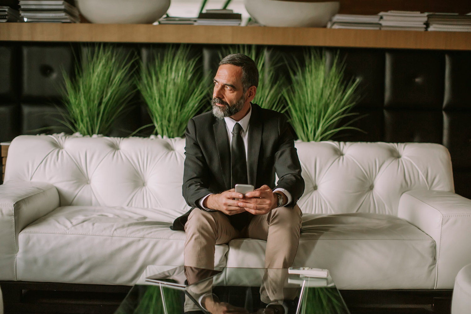 Mature man waiting in a Perth-style lounge with his phone